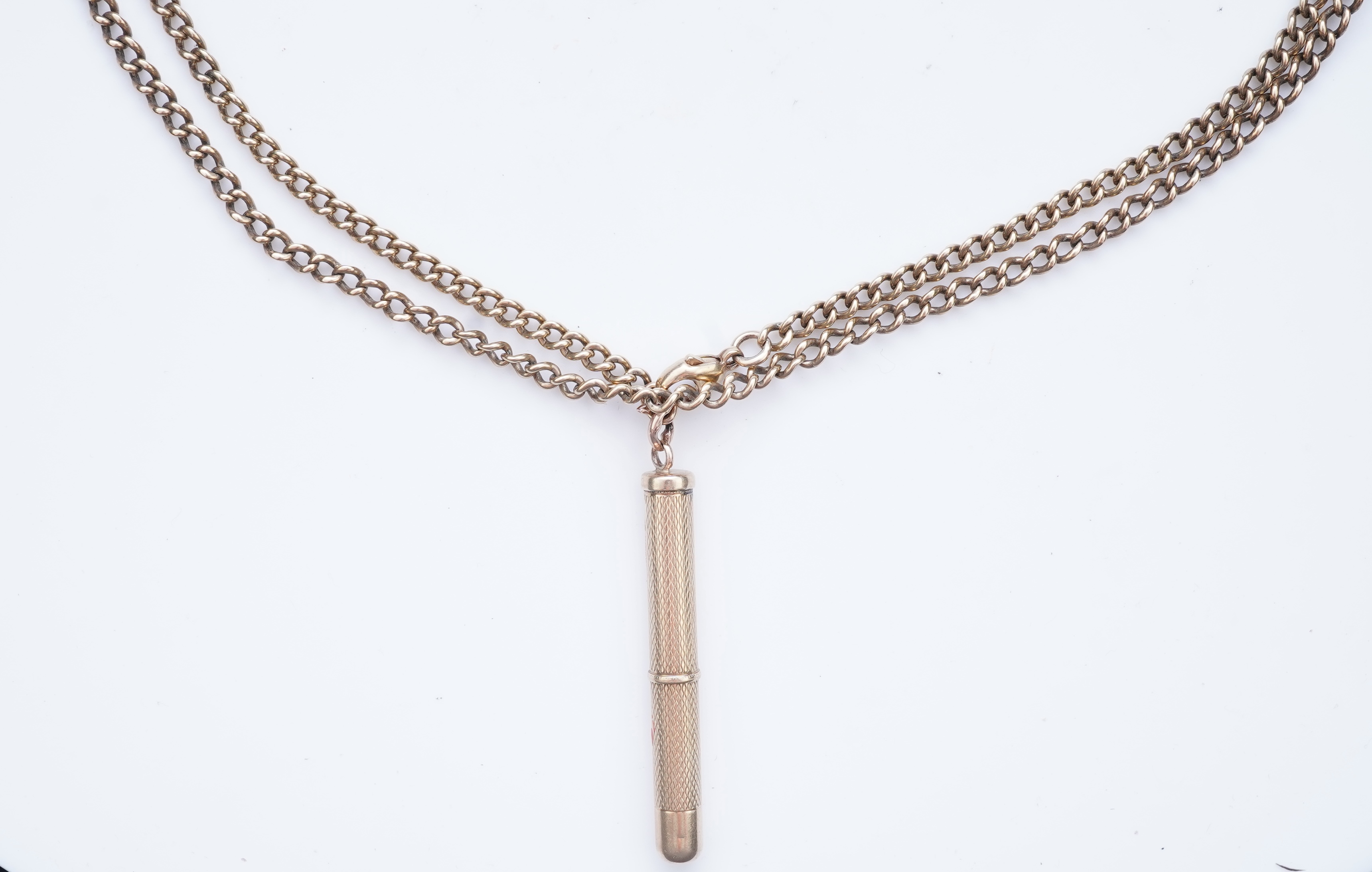 A gold toothpick and chain necklace